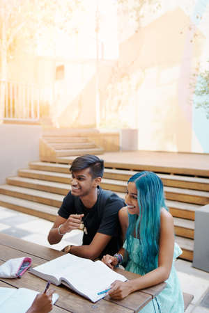 Shot of a young student couple enjoying a break outdoors on campusの写真素材