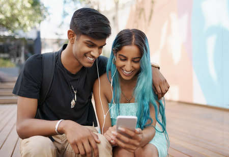 Shot of a young student couple enjoying a break outdoors on campusの写真素材