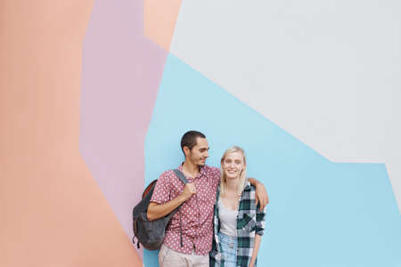 Shot of a cheerful young couple standing outside holding each other while looking at the cameraの写真素材