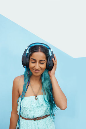 Shot of a cheerful young student listening to music on headphones outside with her eyes closedの写真素材
