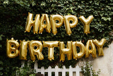 Cropped shot of a sign reading HAPPY BIRTHDAY hanging outsideの写真素材