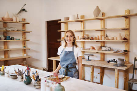 Cropped portrait of an attractive young female artisan working in her pottery workshopの写真素材