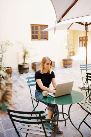 Cropped shot of an attractive young woman using a laptop at a cafeの写真素材