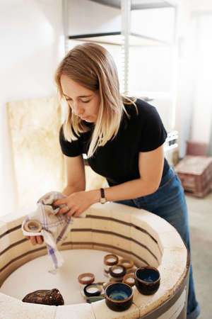 Shot of a young ceramic artist working in her pottery workshopの写真素材