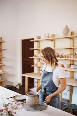 Cropped shot of an attractive young female artisan working in her pottery workshopの写真素材