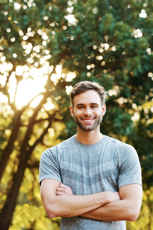 Portrait of a sporty young man standing in a parkの写真素材