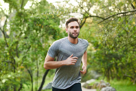 Cropped shot of a young man out for a run in the parkの写真素材