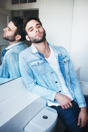 Portrait of a handsome young man posing in a bathroomの写真素材
