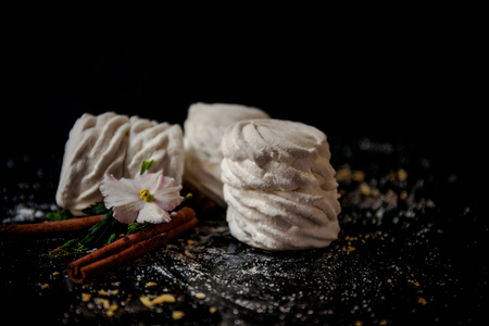 Homemade white marshmallows with cinnamon sticks on blackbackground. Winter timeの写真素材