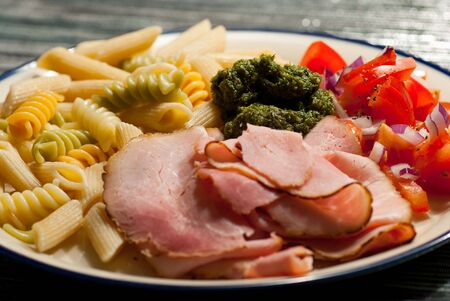 Pasta and  ham accompanied by pesto in Italian dishの写真素材