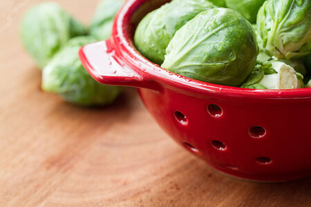 Brussel sprouts in red colanderの写真素材