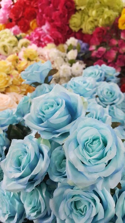 Many blue roses made by fabric isolated on colorful flowers background in the market,wallpaper ,Artificial flowers, craftsの写真素材