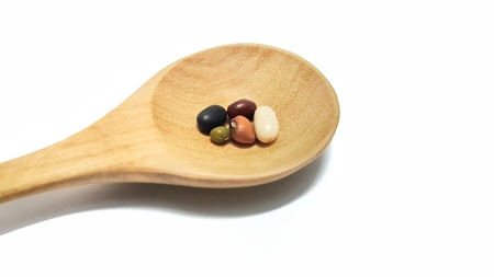 five mixed beans on wooden spoon isolated on white background. raw beans,organic superfood.の写真素材