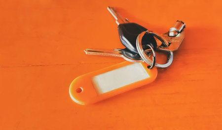 three key and tag isolated on orange wooden background with copy space