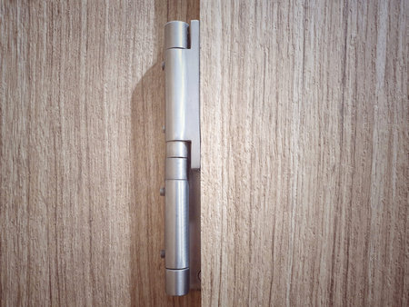 Door hinges in the room isolated on wood background