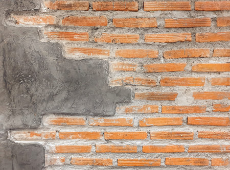 Orange brick wall with cement paving wall with copy space.Weathered stained old stone brick wall....