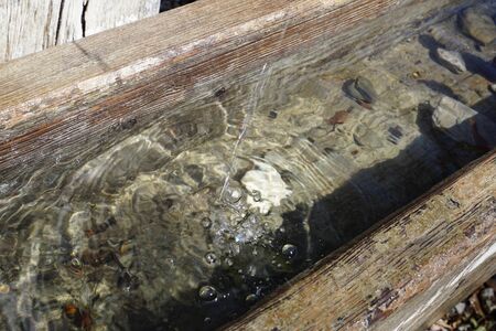 wooden drinking trough with fresh waterの写真素材