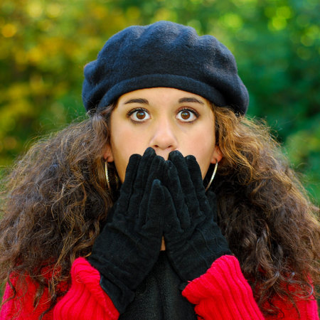 Surprised or scared girl covering her mouth with her hands, eyes wide open