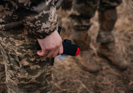 A military man holds a medical tourniquet in his hands to stop blood in first aid and prevent...