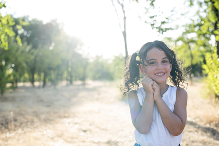 little girl posing for the photographer in the parkの写真素材