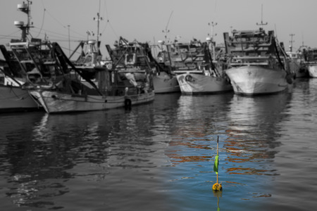 fishing boats in harbor - buoy with flagsの写真素材
