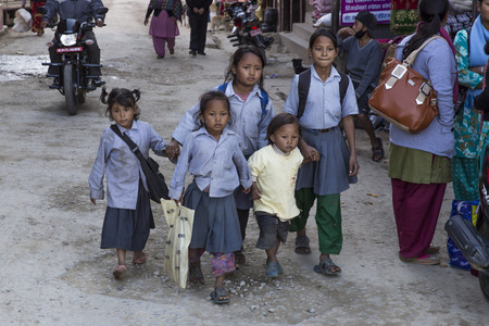 PANAUTI, NEPAL - DECEMBER 2, 2013  five poor children come home after school with the modest and dirty uniform of the public school on december 2, 2013 in Panauti  Panauti is a historical city in Nepal, 36 km South-East from the capital city Kathmandu のeditorial素材