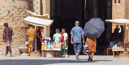 KHIVA, UZBEKISTAN - AUGUST 25, 2016: unidentified people walks near the twin-turreted East Gate of Khiva, Uzbekistanのeditorial素材