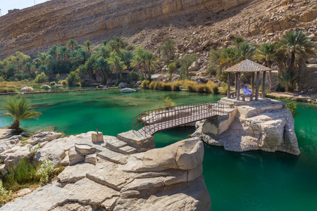 WADI BANI KHALID, OMAN - NOVEMBER 26, 2017:  A man relaxes at the amazing view of the emerald pools in Wadi Bani Khalid, Omanのeditorial素材