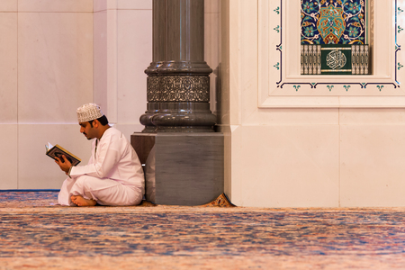 MUSCAT, OMAN - NOVEMBER 30, 2017: a man prays in Sultan Qaboos Grand Mosque in Muscat, Omanのeditorial素材