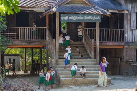 NGAPALI BEACH, MYANMAR - December 3, 2014: children go to elementary school in the fishing village Jade Taw, south of hotels in Ngapali beach.のeditorial素材