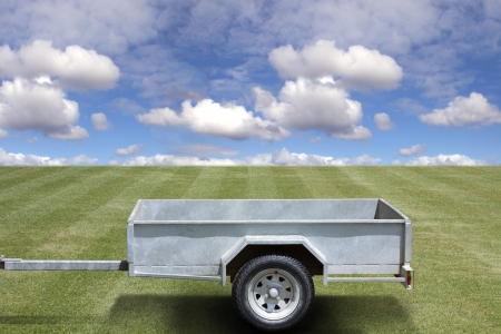 Empty trailer on the green grass and blue sky backgroundの写真素材