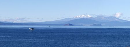 Plain over Lake Taupo, volcanoes of Tongariro National Park in the background, New Zealandの写真素材