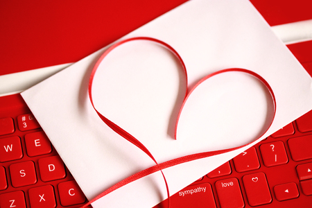 Red heart on red keyboard with a blank card. Valentines Day conceptsの写真素材