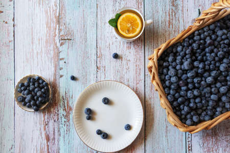 Fresh blueberries, tea with lemon and mint on wooden table backgroundの写真素材