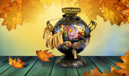 Russian traditional samovar and bagels on the wooden table with autumn leavesの写真素材
