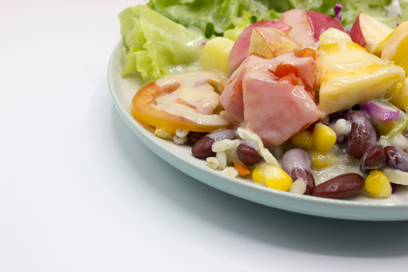Closeup mixed of fresh salad and fruit on dish. Corn, red beans, pineapple and papaya on white background.の写真素材