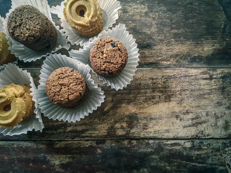 Cookies cream with chocolate chips wrapped in paper placed on a wooden floor.