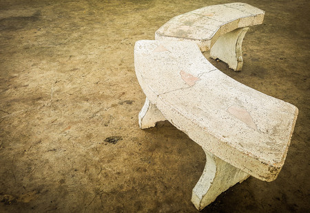 Old marble curved chair on concrete floor.の写真素材