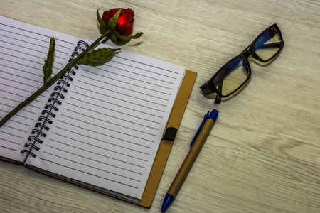 Top view of book and pen with glasses on white wooden background.の写真素材
