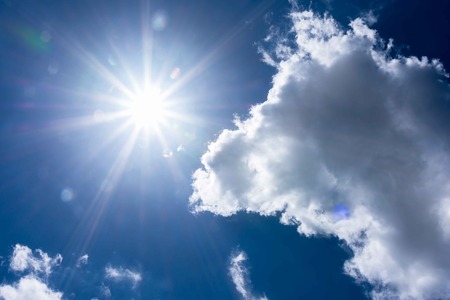 Blue sky and clouds in shining sun with lens flare.の写真素材