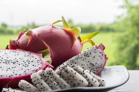 Dragon fruits healthy food in black dish on white wooden and nature  background.の写真素材