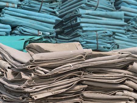 The thick gray and green canvas is stacked. To dry After cleaning, a canvas with a vent is used to keep the sound. And dust during construction.の写真素材
