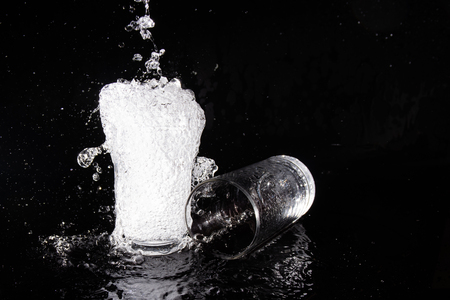 Water splash and crystal glass on black background.の写真素材
