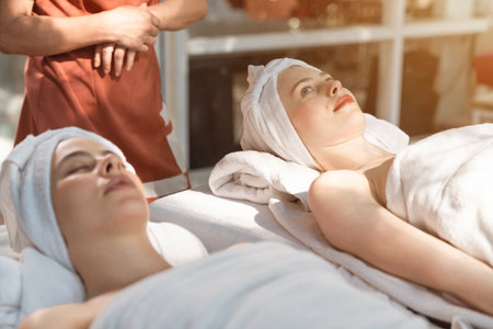 Beautiful young woman relaxed in spa salon,Traditional aroma therapy and beauty treatments,Outdoor spa surrounded by gardens and natural light.の写真素材