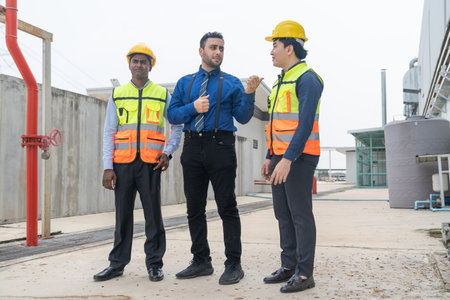 Portrait of confident businessman and engineer talking while walking at construction site outdoors.
