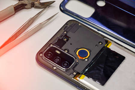 Image of a technician screwing the back of a mobile phone.の写真素材
