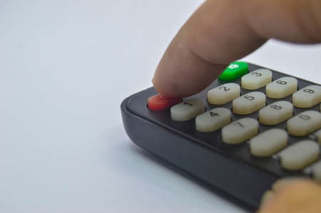 Close-up shot while pressing the remote control on a white backgroundの写真素材