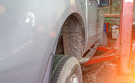 Side view of a car lifted off the ground by a large jack.の写真素材