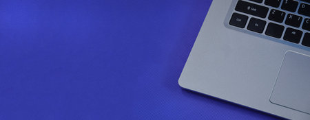 Left view of a white laptop on a blue background.の写真素材
