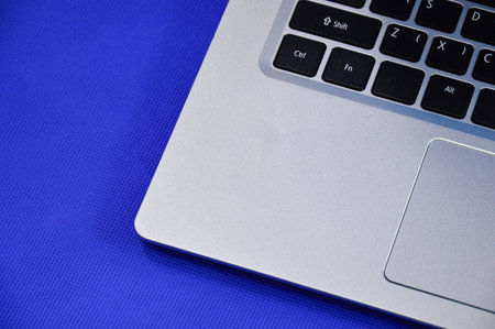 Left view of a white laptop on a blue background.の写真素材